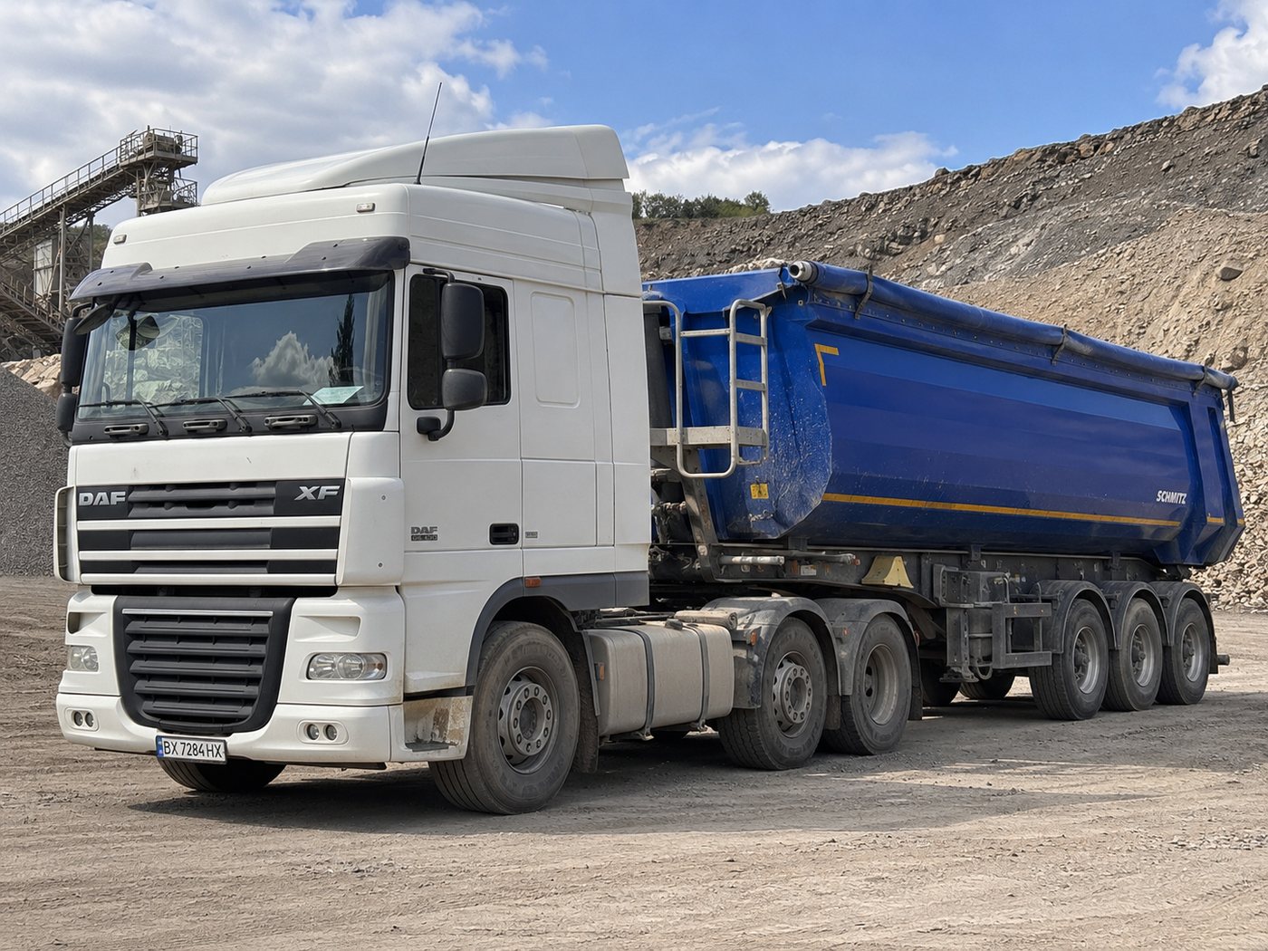 DAF XF 95 з синім самоскидним напівпричепом Schmitz на кар’єрі